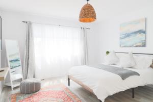 um quarto branco com uma cama e uma janela em Stylish Boho Retreat- 5 Bed - 4 Bath - 15 min to Falls em Thorold