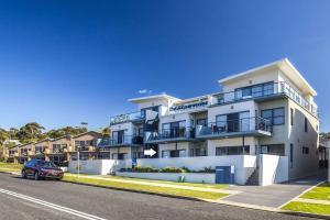 a building with a car parked in front of it at Beachfront 2 in Mollymook