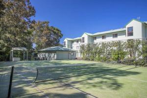 a tennis court with a net in front of a building at Fathoms 3 Ocean Breeze in Mollymook