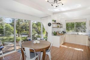 een keuken en eetkamer met een tafel en stoelen bij Relax at The Sands in Mollymook