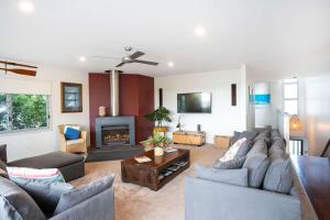 a living room with a couch and a fireplace at Aurora in Mollymook