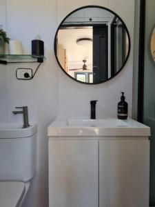 a bathroom with a white sink and a mirror at Tiny Homes in Hartley