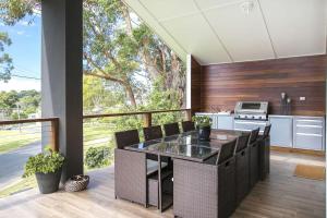 a kitchen with a table and chairs on a balcony at Ocean Blue in Ulladulla