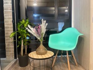 una silla azul sentada junto a una mesa con flores en St. Louis Suites - Movistar Arena, en Bogotá