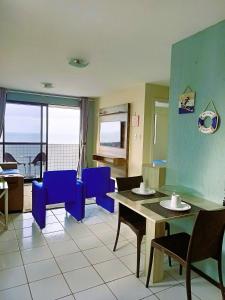 a room with a table and chairs and a view of the ocean at Conforto e melhor vista - 100 metros da praia in Natal