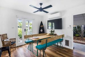 a dining room with a table and a ceiling fan at Villa Marie in Narrawallee +15 photos