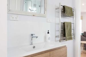 a bathroom with a sink and a mirror at Northstar on Mollymook Beach in Mollymook