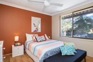 a bedroom with a bed and a window at Narrawallee Retreat in Narrawallee