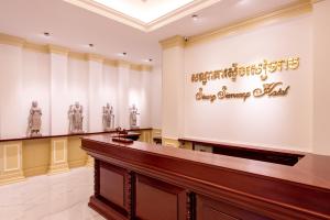 una sala con un banco y estatuas en Steung Siemreap Hotel, en Siem Reap