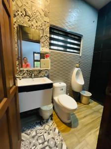 a bathroom with a toilet and a sink and a mirror at Sto Niño Residences Lucena City in Lucena