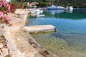 a small boat in a body of water with boats at Apartments by the sea Zaglav, Dugi otok - 12504 in Sali