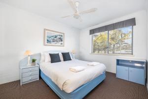 a bedroom with a large bed and a window at Breakers 5 in Mollymook