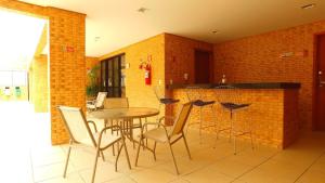 een keuken met een tafel en stoelen en een bakstenen muur bij Edifício Setai Apto 413 ER Hospedagens in Maceió
