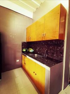 a kitchen with a sink and wooden cabinets at Sto Niño Residences Lucena City in Lucena