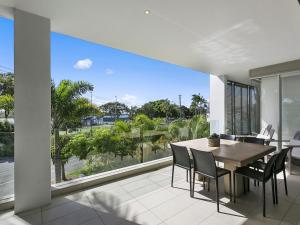 a dining room with a table and chairs and a large window at Unit 2 Wai Cocos 215 Gympie Terrace Noosaville in Noosaville