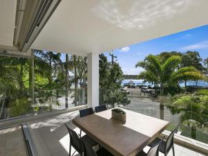 a dining room with a table and chairs and a large window at Unit 2 Wai Cocos 215 Gympie Terrace Noosaville in Noosaville