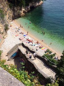 a group of people on a beach in the water at Apartments by the sea Rijeka - 13293 in Rijeka