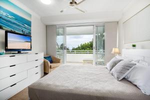 1 dormitorio con 1 cama grande y TV en Unit 4 Cote DAzur 6 Douglas Street Sunshine Beach, en Sunshine Beach