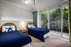 1 dormitorio con 2 camas y ventana grande en Unit 4 Cote DAzur 6 Douglas Street Sunshine Beach, en Sunshine Beach