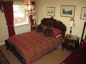 a bedroom with a bed, chair, lamp and a painting on the wall at Killyon Guest House in Navan