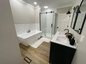 Un baño blanco con bañera y lavabo. en Peaceful Sears, Roebuck and Company Mail Order Home., en Henderson 9 fotos más