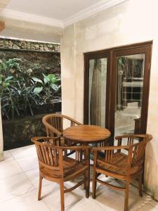 a wooden table and two chairs and a table at Darma Yogi House in Ubud