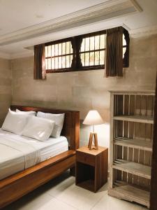 a bedroom with a large bed and a window at Darma Yogi House in Ubud