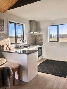 a kitchen with a sink and a counter top at Peak View Cabin - Ben Ohau - Stylish Seclusion in Twizel
