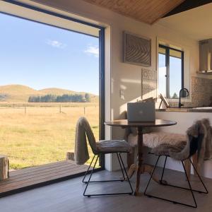 cocina con mesa y ordenador portátil en una mesa en Peak View Cabin - Ben Ohau - Stylish Seclusion, en Twizel