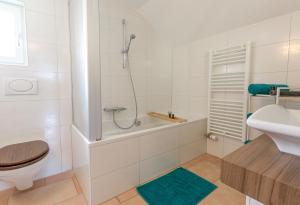 La salle de bains est pourvue d'une baignoire, de toilettes et d'un lavabo. dans l'établissement Spirit Apartments - Balkon mit Seesicht - Parkplatz, à Brienz