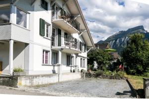 - un bâtiment blanc avec 2 balcons sur le côté dans l'établissement Spirit Apartments - Balkon mit Seesicht - Parkplatz, à Brienz