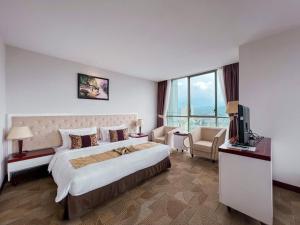 a hotel room with a large bed and a tv at Sapaly Lao Cai City Hotel in Lao Cai
