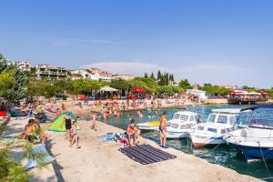 a group of people on a beach with boats in the water at Apartments by the sea Sveti Petar, Biograd - 358 in Sveti Petar