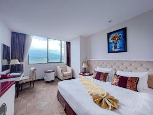 a hotel room with a bed and a large window at Sapaly Lao Cai City Hotel in Lao Cai