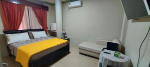 um pequeno quarto com uma cama e uma janela em Casa Serena em Guayaquil