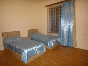 a bedroom with two beds and a window with curtains at Artyomi Toon in Dilijan