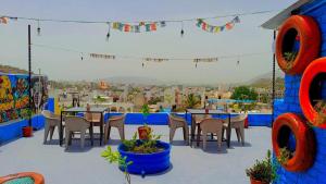a patio with tables and chairs and a view of a city at Hill Paradise Home Stay in Udaipur