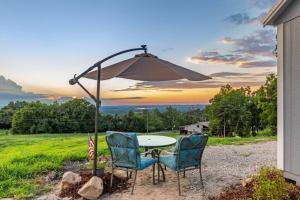 uma mesa e duas cadeiras debaixo de um guarda-sol em Chasing Views Tiny House em Dandridge