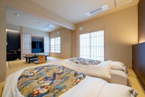 a bedroom with two beds and a living room at Nishiyama Ryokan - 1953年創業 in Kyoto