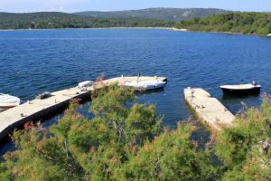 two boats are docked at a dock on a lake at Apartments by the sea Veli Rat, Dugi otok - 438 in Veli Rat