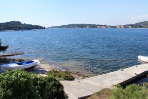 two boats on the shore of a large body of water at Apartments by the sea Veli Rat, Dugi otok - 438 in Veli Rat