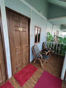 Zimmer mit zwei Stühlen und einer Holztür in der Unterkunft Regina's Place in Mandrem