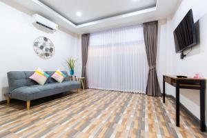 uma sala de estar com um sofá e uma televisão em Summer Sea Villa Khanom ซัมเมอร์ซีวิลล่า ขนอม em Ban Phang Phrao