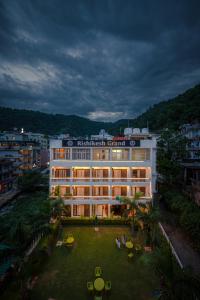 a large white building with a lawn in front of it at Hotel Rishikesh Grand by Kool-Stays in Rishīkesh