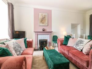uma sala de estar com dois sofás vermelhos e uma lareira em North Stables - House Of Dun em Montrose