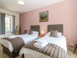 two beds in a room with pink walls at North Stables - House Of Dun in Montrose