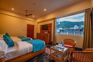 1 dormitorio con cama y ventana con vistas en Hotel Rishikesh Grand by Kool-Stays, en Rishīkesh