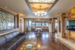 a living room with a couch and a television at Jeju Nine Resort in Jeju