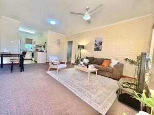 sala de estar con sofá y mesa en Neat 2 bedroom apartment, with free parking, en South Hedland