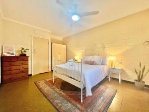 1 dormitorio con 1 cama y ventilador de techo en Neat 2 bedroom apartment, with free parking, en South Hedland